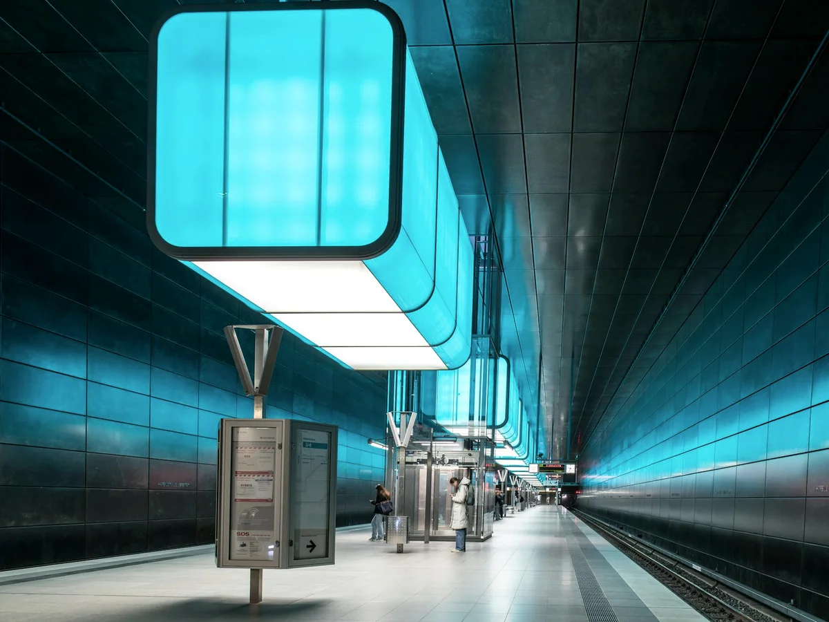Futuristic subway station in Hamburg with vivid blue lighting and modern architecture.