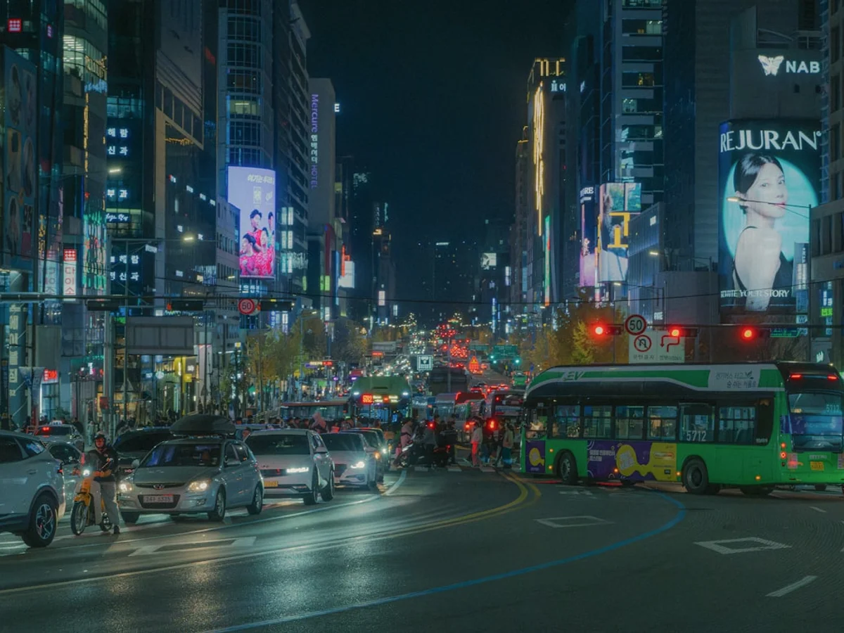 Busy city street at night with traffic and neon lights
