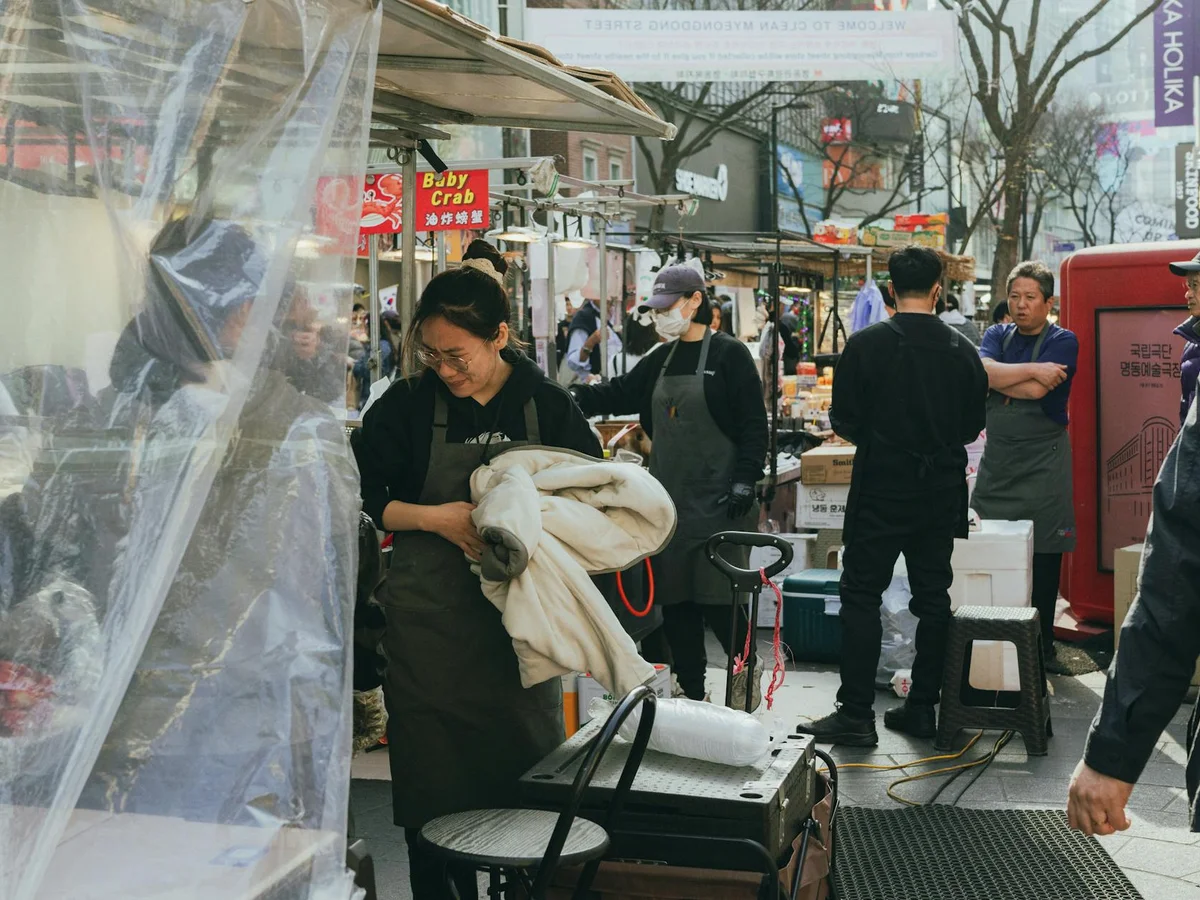 Explore the lively street market scene in Myeongdong, Seoul, showcasing Korean culture and culinary delights.